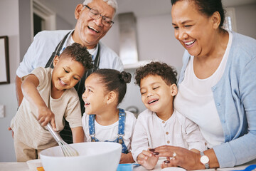 Are those little balls or lumps. Shot of a mature couple baking with their grandkids at home.