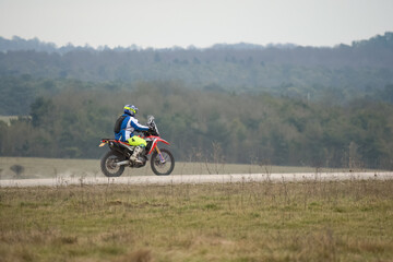 a motor cyclist (biker) riding his off-road motorbike along a stone track on Salisbury Plain, Wiltshire