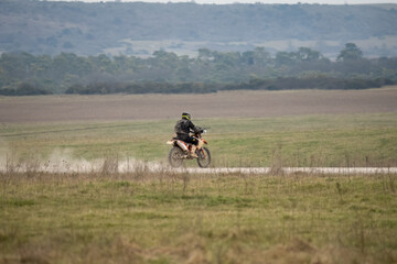 a motor cyclist (biker) riding his off-road motorbike along a stone track on Salisbury Plain, Wiltshire