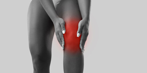 Crop close up white and black shot of unhealthy woman suffer from kneecap ache. Pain in knee...