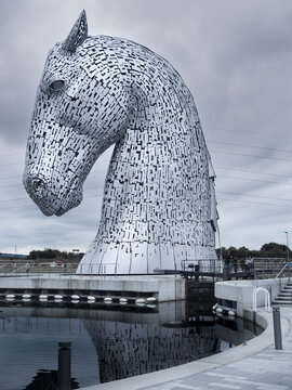 Grangemouth, Scotland - 08.25.2016: Giant metal Kelpies sculptures on a cold and cloudy day. Famous tourist attraction in Scotland. Giant horses statues.