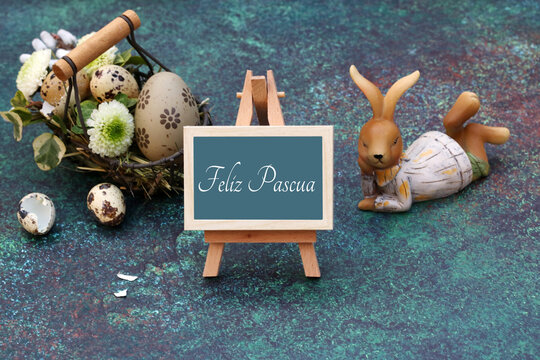 Felices Pascuas. Conejo de Pascua y huevos de Pascua con saludos de Pascua en un caballete.