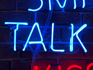 Neon sign that says the word TALK. 