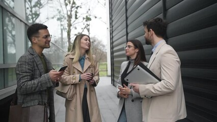 Young businesspeople standing in front of office building talking sharing experience about success business ideas and suggestions improving working conditions of employees and clients