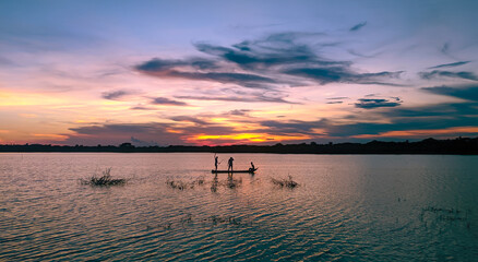 Three friends are enjoying the beautiful moment in the river at sunset.
