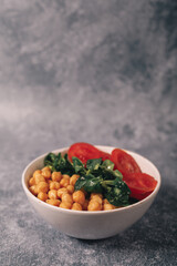 veggie poke filled with chickpeas, arugula and tomato, copy space, vertical shot