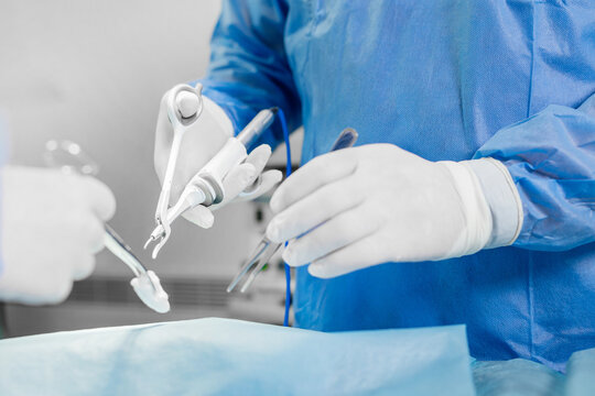 Doctor using ultrasonic surgery scissors during operation. Ultrasonic scalpel and scissor grip