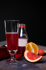 a glass glass with a drink and various fruits on the table