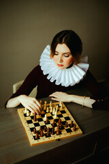 Portrait of a beautiful young woman with an antique white frill around her neck, who is playing a...