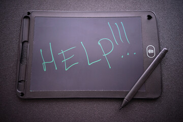 The inscription help on the tablet screen.A request for help on the screen. Handwritten inscription.