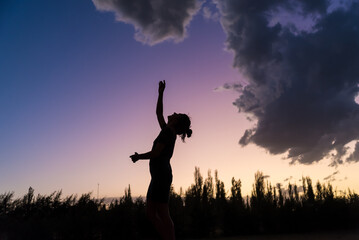 A girl in a field with the sky in the background