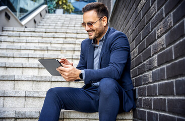 Happy smiling businessman making video call with his client via tablet. Business, lifestyle concept