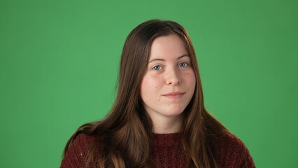 Obraz premium Green screen portrait of young beautiful smiling casual female. Teen girl talking to friends online, blogging, laughing. Camera point of view