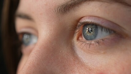 Fototapeta premium Close up profile of woman face, girl opening grey blue eyes, attractive. Natural beauty with freckles. Gorgeous with long eyelashes and attractive appearance. slow motion.