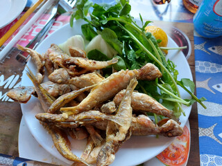 Fried fish on a plate with green salad