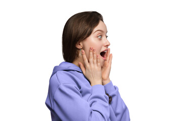 The girl is amazed in excitement on a light background, her hands on her cheeks, her mouth open.