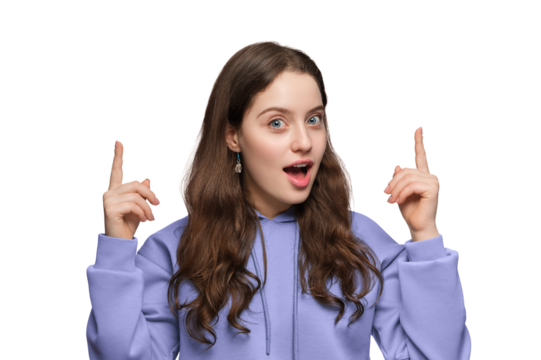 A young and surprised woman with long hair and blue eyes points upward. The girl is wearing a violet oversized hoodie.