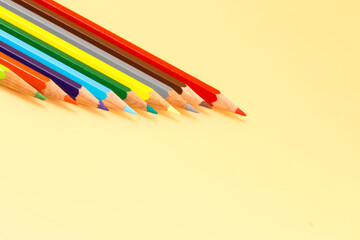 set of colored pencils with a sharp tip placed on an orange surface
