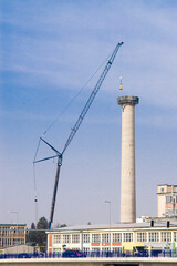 Zubri Czech Rep 1st March 2021 DISMANTLE OF CONCRETE INDUSTRIAL CHIMNEY using a crane and a little excavator. Scene with public traffic passing under the chimney
