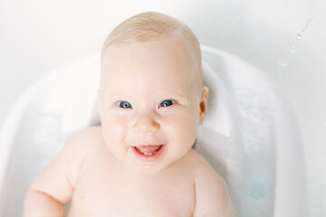 Cute baby girl taking a bath. Child health care. - 580106208