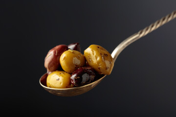 Spicy olives in a big spoon.