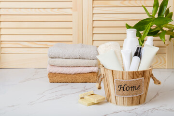 Fototapeta na wymiar Home spa. Everyday hygiene. Natural bodycare products on background of bathroom wooden louvered doors. Eco-friendly hair care products. Natural cosmetics. Shower gel, Soap, towels and bath oil