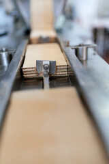 Huge factory line for sweet food and cookies production. Close up shot of conveyor belt waffle production line.