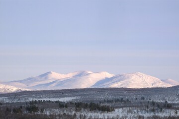 Beautiful snowy mountain panorama in Abisko National Park (Abisko nationalpark), Sweden, Arctic Circle, Swedish Lapland. Little silhouettes of people on trail.