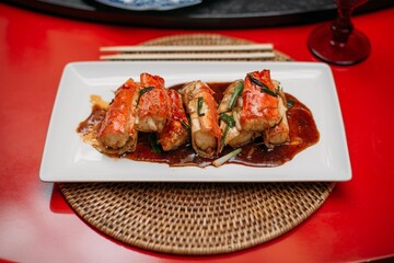 A ready-made dish of fresh red Kamchatka crab legs on the table in the restaurant hall.  Cooked crab meat in a shell on a plate
