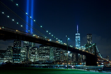 Fototapeta na wymiar Brooklyn bridge with Tribute in Light . The installation of 88 searchlights has been displayed annually in remembrance of the September 11, 2001 attacks.