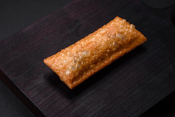 Delicious fresh crispy pie with cherry jam on a wooden cutting board