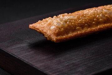 Delicious fresh crispy pie with cherry jam on a wooden cutting board