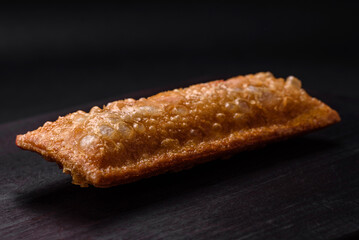 Delicious fresh crispy pie with cherry jam on a wooden cutting board