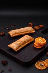 Delicious fresh crispy pie with cherry jam on a wooden cutting board