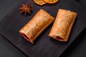 Delicious fresh crispy pie with cherry jam on a wooden cutting board