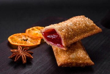 Delicious fresh crispy pie with cherry jam on a wooden cutting board