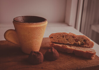 Edible cup made of cookies. Coffee with pastries. Coffee time. Matte image of food and drink. Shtolen and chocolate truffle.
