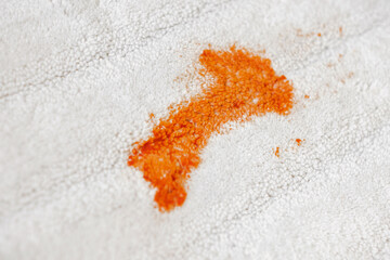 Tomato stain on a white carpet indoors.