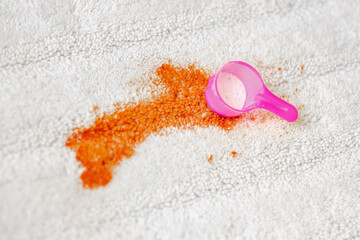 Using of bleaching powder a white carpet indoors. Measuring spoon in dirty spot. Cleaning. closeup. - obrazy, fototapety, plakaty