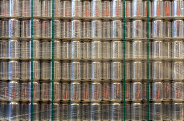 Background with a pallet of empty aluminum cans wrapped in film in a warehouse