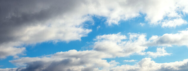 Fototapeta premium White curly clouds in the blue sky, panorama