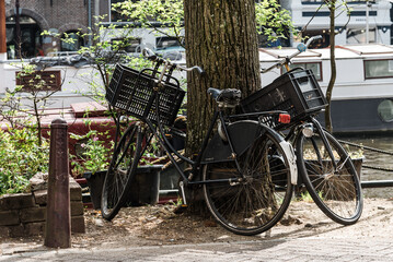 Fototapeta na wymiar Old bicycles parked by the canal in Amsterdam, Netherlands
