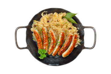 Gebratene Nürnberger  Röstbratwürstchen mit Sauerkraut in der Eisenpfanne auf weißem Hintergrund - Fried Nuremberg sausages with sauerkraut served in an iron frying pan on white background