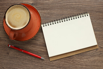 Modern office desk with notepad and coffee cup. Blank notepad page for entering text in the middle. Top view, flat lay.