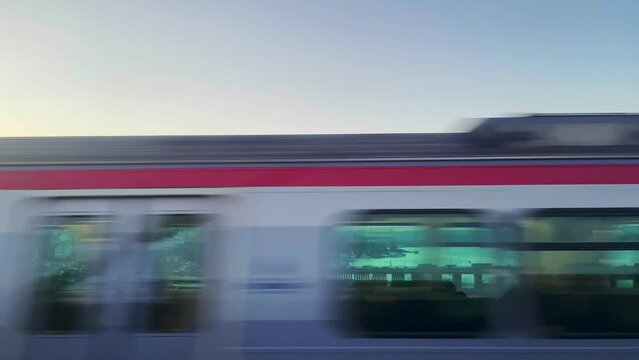 Oncoming train cars passes by, view from window, fast speed, blurred motion