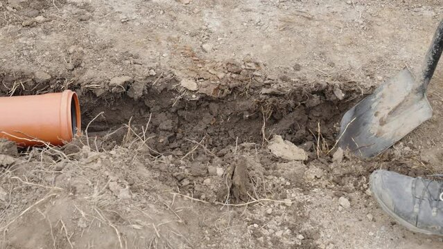 digging in the ground for plastic pipes for water and waste.