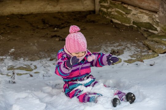 A little girl enjoys the sunny and cold winter wonderland of the north. The old log walls crackle from the frost.