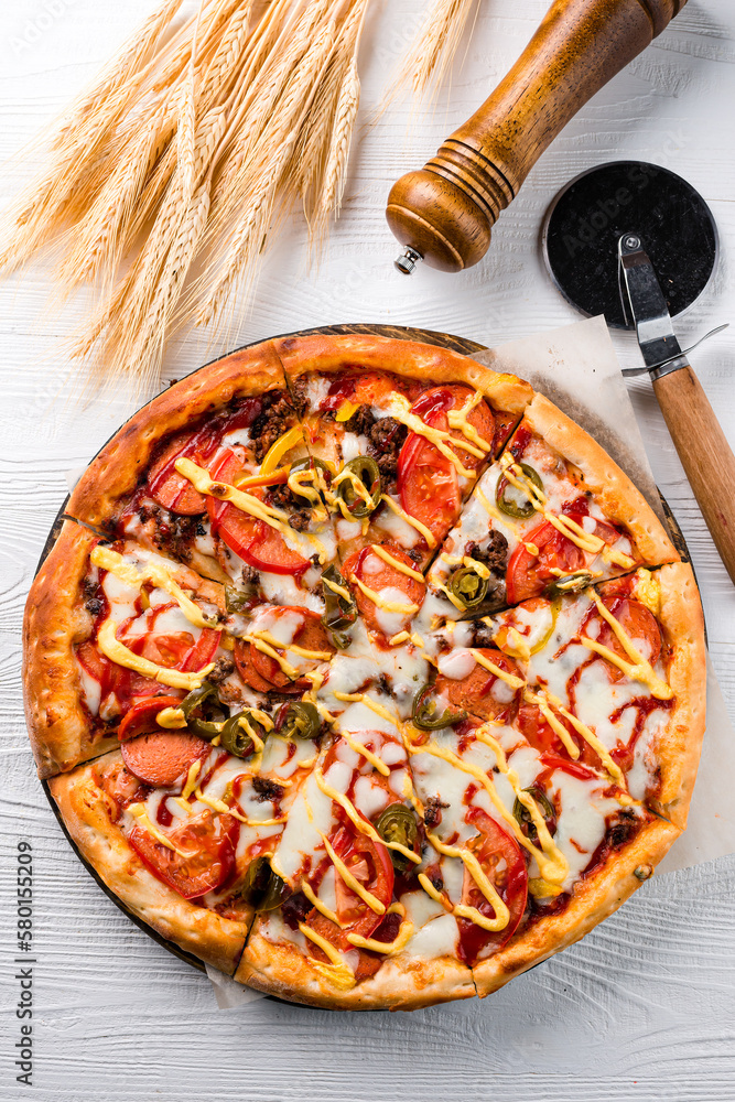 Wall mural Italian lunch pizza with sausages, jalapeno pepper, mozzarella, tomatoes and sauce.