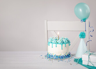 Blue Birthday cake, presents, hats and balloons over light grey background. - 580157495
