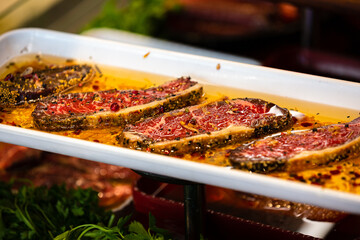 Meat department, showcase with variety of meat in different cuts. Inside an supermarket. Different types of fresh meat arranged in an orderly manner.
